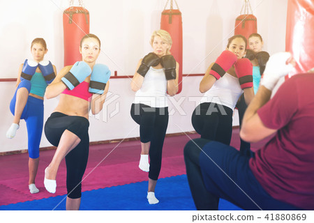 Group of smiling female are doing kick in gym Group of smiling female are doing kick in gym 41880869