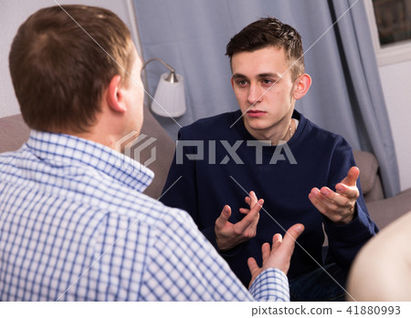 Adult male with his anxious son are resting together and talking about teenage secrets 41880993