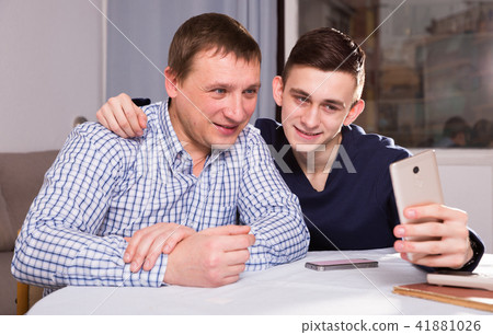 Guy with his father are resting and taking selfie by phone Guy with his father are resting and taking selfie by phone 41881026