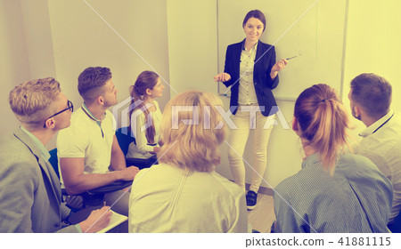 Female teacher lecturing to students at auditorium 41881115