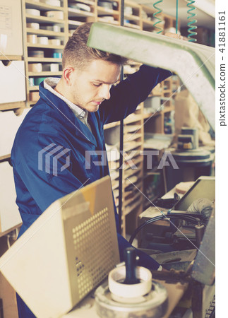 Young smiling male working with trimming machine 41881161