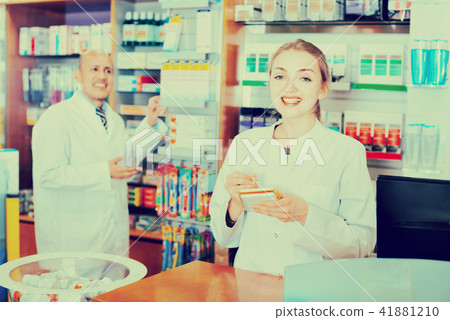 Friendly positive professional pharmaceutists at reception Friendly positive professional pharmaceutists at reception 41881210