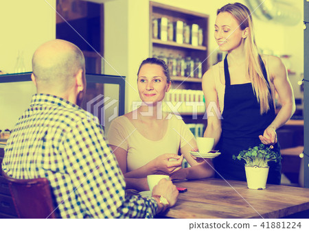 waiter girl brought cup of coffee for couple of different aged people 41881224