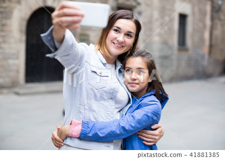 Smiling mother and daughter taking photo Smiling mother and daughter taking photo 41881385