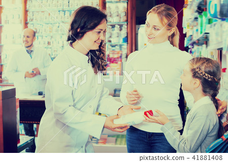 Cheerful woman pharmacist helping customers 41881408
