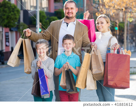 Happy family with two kids holding shopping bags Happy family with two kids holding shopping bags 41881612