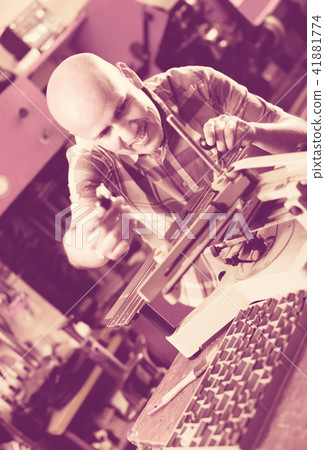 Workman making mailbox plate in workshop. 41881774