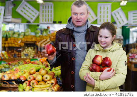Young father looking for ripe apples, shopping with daughter Young father looking for ripe apples, shopping with daughter 41881782