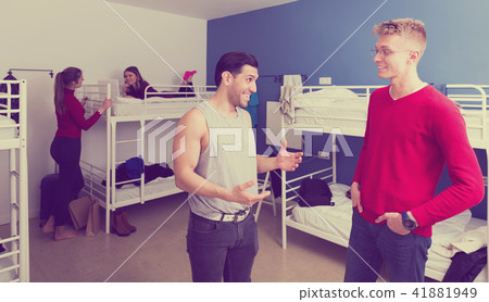 Guys discussing in hostel bedroom 41881949