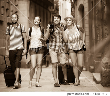 Couples with baggage walking the city. 41881997