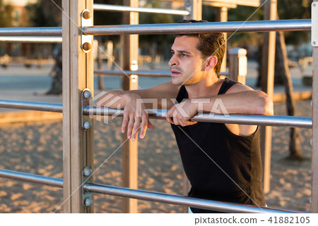 Sporty man near outdoor wall bars Sporty man near outdoor wall bars 41882105