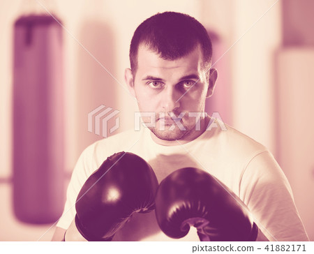 sportsman in the boxing hall practicing boxing punches sportsman in the boxing hall practicing boxing punches 41882171