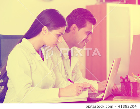 Family doctors with stethoscope working in office together Family doctors with stethoscope working in office together 41882204