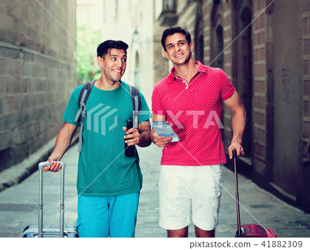 Two friends are walking with beer and watching Two friends are walking with beer and watching 41882309