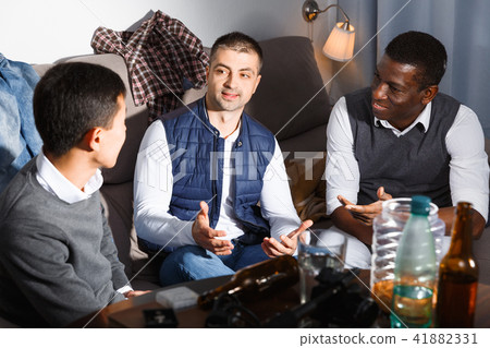 Cheerful men talking on sofa Cheerful men talking on sofa 41882331