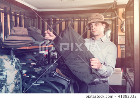 Portrait of adult man hunter looking hunt equipment Portrait of adult man hunter looking hunt equipment 41882332