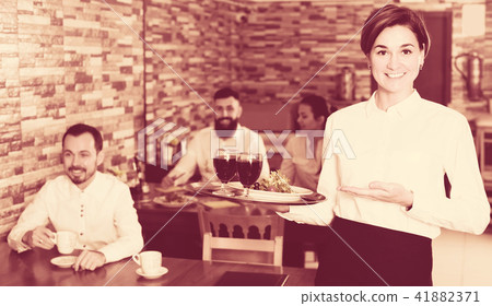 Waiter bringing order for guest in country restaurant Waiter bringing order for guest in country restaurant 41882371