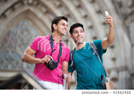 Men are walking with suitcases and making selfie Men are walking with suitcases and making selfie 41882488