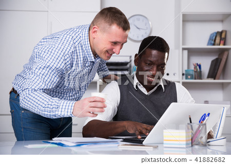 Two men working with computer in office Two men working with computer in office 41882682