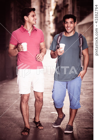 Male tourists walking with coffee 41882764