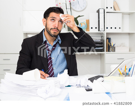 Adult businessman is sad because he is having issues at work place Adult businessman is sad because he is having issues at work place 41882809