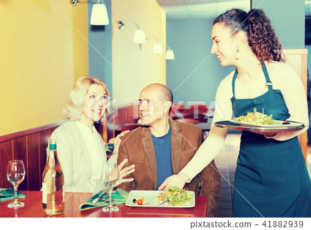 Waitress serving senior customers . Waitress serving senior customers . 41882939