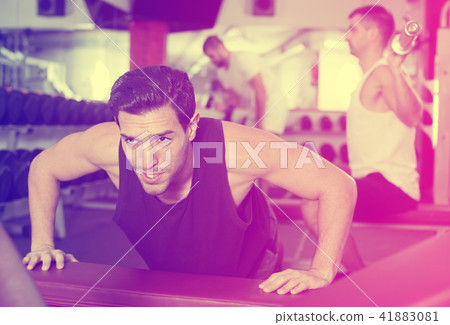 Man doing push-ups on bench in gym Man doing push-ups on bench in gym 41883081