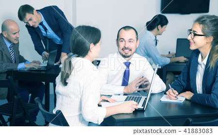 People working productively on business project together People working productively on business project together 41883083