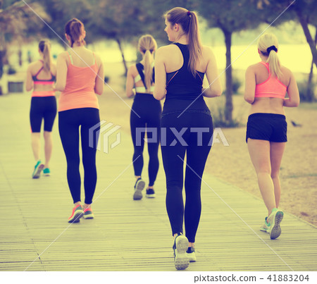 Women running along embankment in sunny morning Women running along embankment in sunny morning 41883204