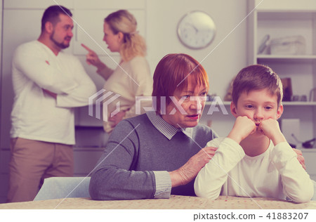 Woman calming boy during parents quarrel Woman calming boy during parents quarrel 41883207