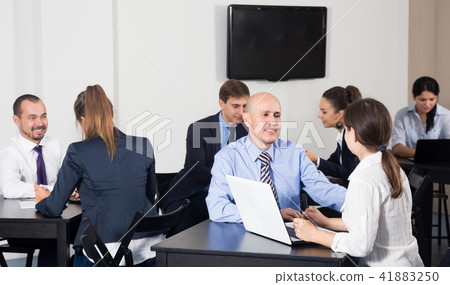 Group of colleagues with laptops having a productive day Group of colleagues with laptops having a productive day 41883250