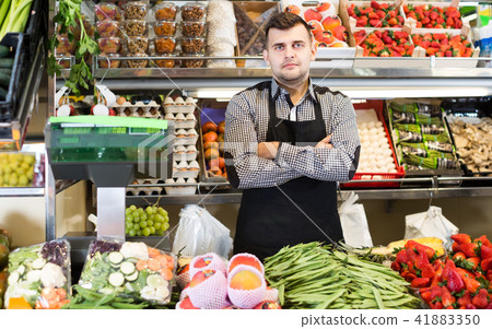male seller showing assortment of grocery shop 41883350