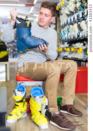 Customer male is trying on boots for skiing 41883413