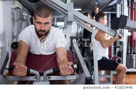 Man training on fitness machine in gym 41883446