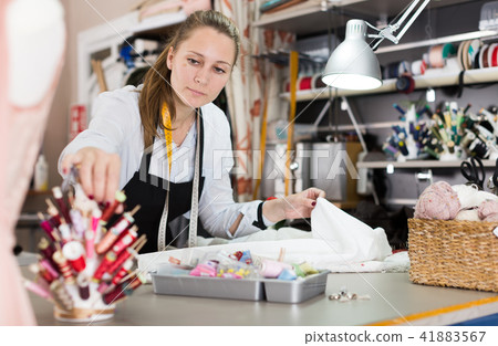 Female professional sewer with textile at sewing workshop 41883567