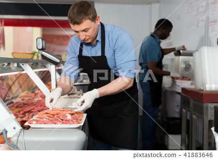 Butchers working behind counter 41883646