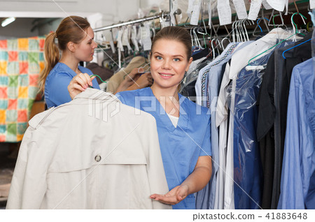 Woman worker holding clean garment 41883648