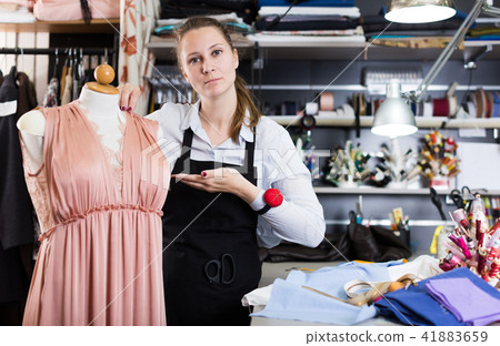 Portrait of woman seamstress who is standing on her workplace Portrait of woman seamstress who is standing on her workplace 41883659
