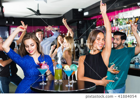 Women are drinking cocktails and having fun in nightclub. Women are drinking cocktails and having fun in nightclub. 41884054