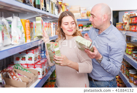 Family couple customers choosing groats in grocery food shop Family couple customers choosing groats in grocery food shop 41884132