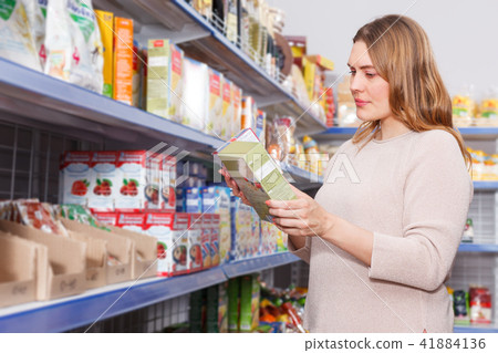 Smiling woman buyer with assortment of grocery food store 41884136