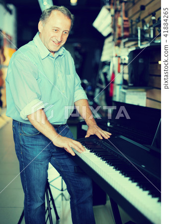 Musician male is choosing keyboard and playing on it Musician male is choosing keyboard and playing on it 41884265