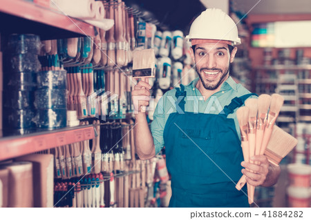 Handyman preparing for renovation works choosing brushes in pain 41884282