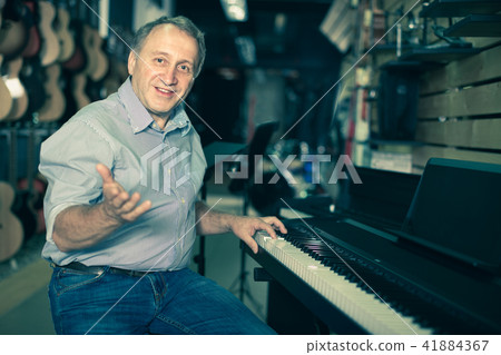 Smiling musician is playing on modern keyboard 41884367