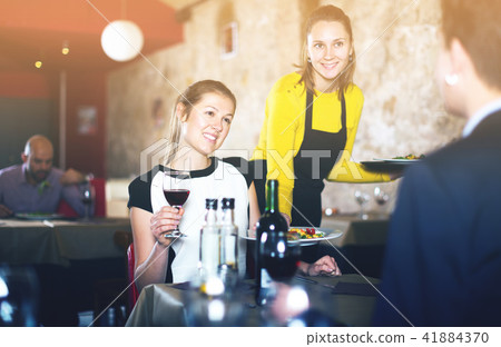 Waitress bringing ordered dishes Waitress bringing ordered dishes 41884370