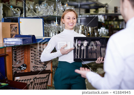 Female shopping assistant offering cutlery 41884945