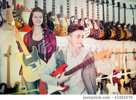 Teenagers choosing electric guitar Teenagers choosing electric guitar 41885076