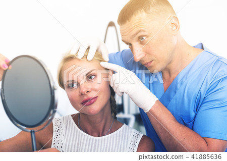 Man doctor is preparing female patient to procedure Man doctor is preparing female patient to procedure 41885636
