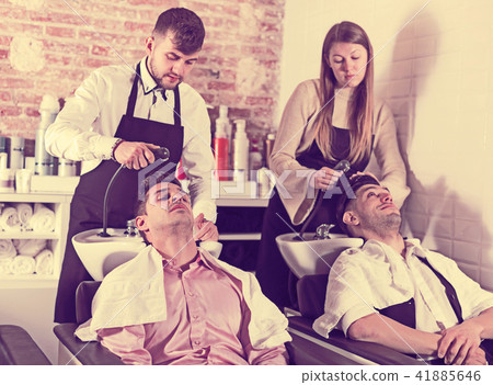 Men relaxing while hairdressers washing their hair 41885646