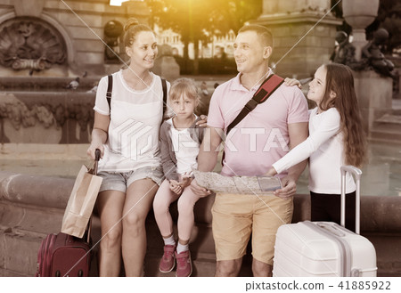 Smiling family of four visiting sights with map Smiling family of four visiting sights with map 41885922